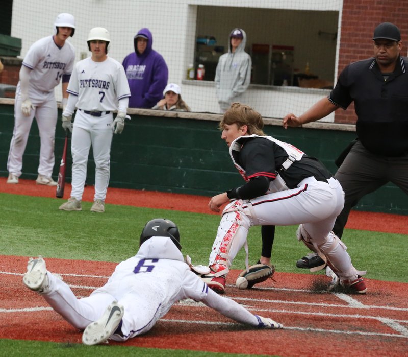 Pittsburg sophomore Landen Proffitt slides in safely as the ball gets away from Labette County catcher Kaiden Nash during their game Tuesday at Jaycee Ballpark. BROCK SISNEY / THE MORNING SUN