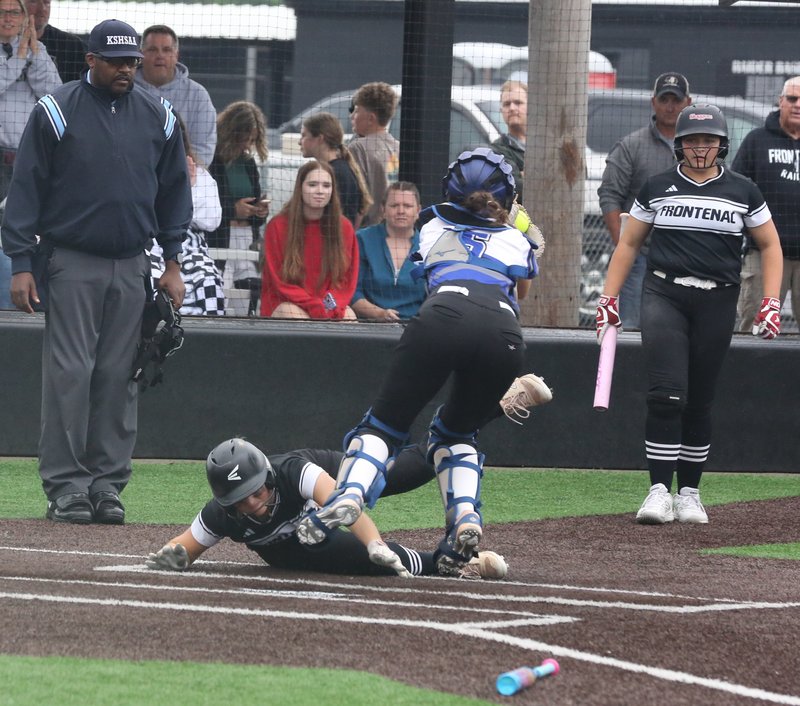 Softball players slides in under the tag